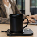 Pursonic Sip & Charge 2-in-1 wireless charger and mug warmer on a desk with a mug and electronic devices.